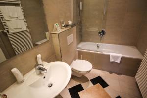 ein Badezimmer mit einem Waschbecken, einem WC und einer Badewanne in der Unterkunft Ringhotel Zum Goldenen Ochsen in Stockach