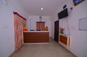 Pine Tree Munnar في مونار: غرفة بها مكتب وتلفزيون