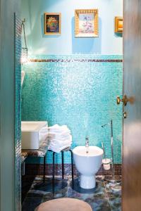 a blue tiled bathroom with a sink and a toilet at Rooms Roma - Monti in Rome
