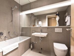 a bathroom with a sink, toilet and bathtub at Park Boutique Hotel in Varaždin