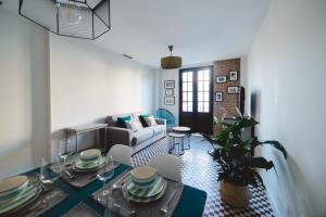 uma sala de estar com uma mesa e um sofá em El Mirador de Catalina em Sevilha
