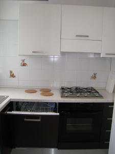 una cucina con armadi bianchi e piano cottura di Appartamento Adriatico a Cesenatico