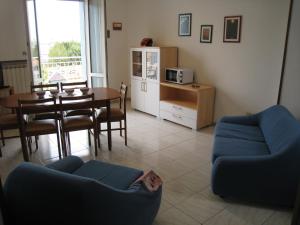 un soggiorno con tavolo e divano blu di Appartamento Adriatico a Cesenatico