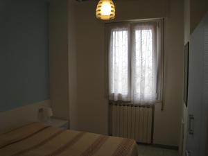 una camera con letto e finestra di Appartamento Adriatico a Cesenatico