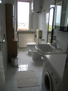 チェゼナーティコにあるAppartamento Adriaticoのバスルーム(トイレ2つ、シンク、洗濯機付)