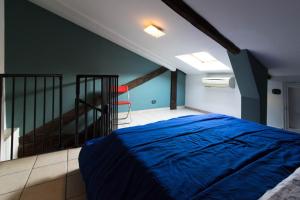 una camera con un letto blu e una scala di Bilo Bellezia a Torino