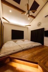 Bett auf einem Holzboden mit Deckenventilator in der Unterkunft Guest Villa Hakone Yumoto 201 in Hakone