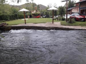 a stream of water in a river with umbrellas at Cabañas Tierra del Sol Aldea de Montaña in Los Árboles