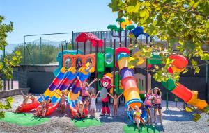 un grupo de niños jugando en un parque infantil al aire libre en GranSerena Hotel, en Torre Canne