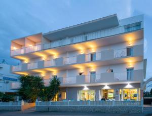 Un grand bâtiment blanc avec des lumières sur lui dans l'établissement Hostal Anibal - AB Group, à Sant Antoni de Portmany