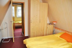 a bedroom with a yellow bed in a attic at Ferienhaus Exner hinter dem Deich in Cuxhaven