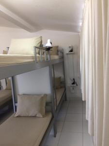 a room with two bunk beds and a curtain at Hostel Pajuçara in Maceió