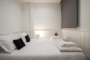 ニースにあるFrançoisのベッドルーム1室(白いベッド1台、タオル付)