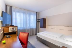 a hotel room with a bed and a desk with a computer at Ferrotel Duisburg - Partner of SORAT Hotels in Duisburg