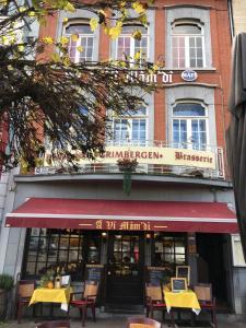 um restaurante com mesas e cadeiras em frente a um edifício em Les Appartements Â Vî Mâm'dî em Malmedy