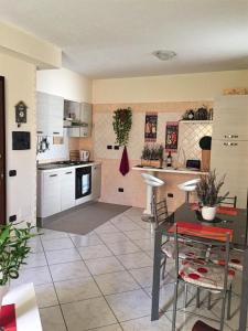 una cucina e un soggiorno con tavolo e sedie di Gaia House a Oristano