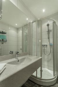 a bathroom with a sink and a shower at Ferrotel Duisburg - Partner of SORAT Hotels in Duisburg