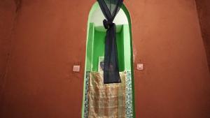 uno specchio con un arco nero su un muro di Dar Yaya a M'Hamid