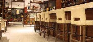 a bar with a row of white bar stools at Hotel Sliško in Zagreb