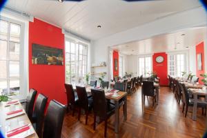 ein Restaurant mit Tischen, Stühlen und roten Wänden in der Unterkunft Stadthotel Jülich in Jülich