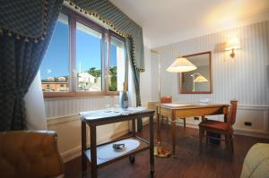 a hotel room with a desk and a window at Hotel Centro di Spiritualità Padre Pio in San Giovanni Rotondo