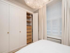 - une chambre avec un lit blanc et un lustre dans l'établissement Harju Old Town Apartment, à Tallinn