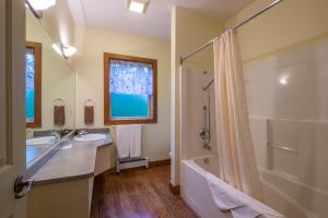 een badkamer met een bad, een wastafel en een douche bij Kiwi Cove Lodge in Ladysmith +32 foto's