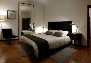 a bedroom with a large bed and a mirror at Casa de Santo Amaro in Vila do Conde