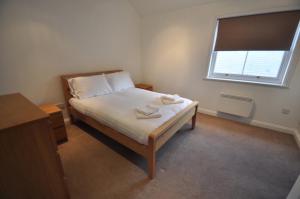 a small bedroom with a bed and a window at Princes Dock Chambers 9 in Hull