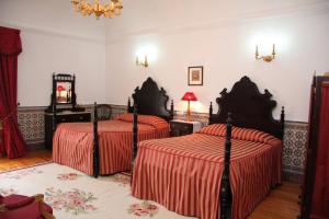 a bedroom with two beds and a mirror at Casa D. Diogo in Arraiolos