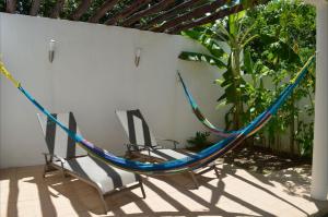 two chairs and a hammock on a patio at Casa Mango in Valladolid