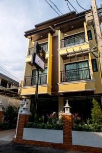 un edificio amarillo con un cartel delante en Villa Thai Orchid (adult only) en Chiang Mai