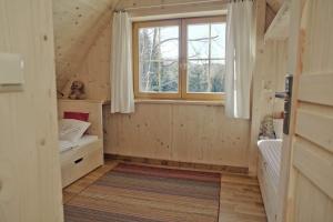 ザコパネにあるDomek Pod Sosnąの窓とベッドルームが備わる小さな家です。
