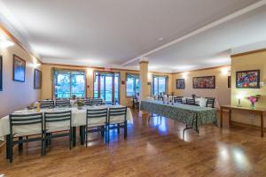 a dining room with tables and chairs and windows at Kiwi Cove Lodge in Ladysmith