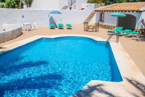 a large blue swimming pool with chairs and umbrellas at Fustera Pedros - old-style country house in Benissa in Benissa
