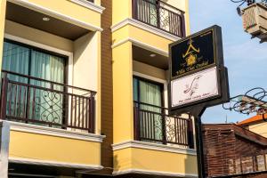 a sign in front of a yellow building with balconies at Villa Thai Orchid (adult only) in Chiang Mai