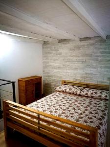 パレルモにあるA'TAVERNUZZAのレンガの壁、木製ベッド付きのベッドルーム1室が備わります。
