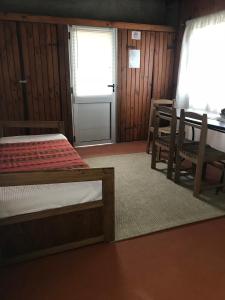 1 dormitorio con 1 cama, mesa y sillas en Conaguademar, en La Paloma