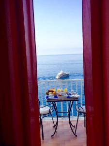 a table on a balcony with a cruise ship in the ocean at Donna Giulia in Amalfi