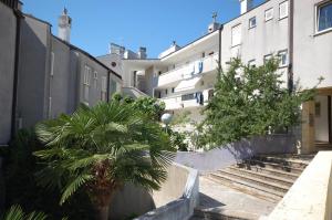 a building with palm trees in front of it at Mezlar Apartment by El-pi Tours in Njivice