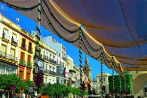 una calle con edificios y una sombrilla grande en Plaza San Francisco luxury apt, en Sevilla