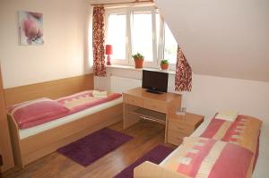 a bedroom with two beds and a desk and a window at Koral in Koszalin