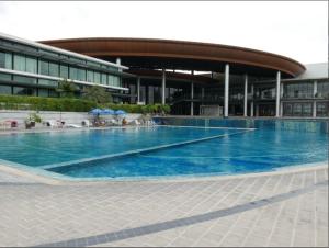 a large swimming pool in front of a building at Ayi Home in Bangkok