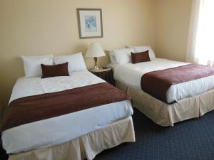 a hotel room with two beds and a lamp at Beau Rivage Golf and Resort in Wilmington