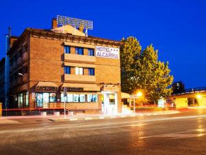 a building on the corner of a street at night at Hotel Alcarria in Guadalajara