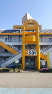 um grande edifício amarelo com um sinal nele em Premiere Classe Plaisir em Plaisir