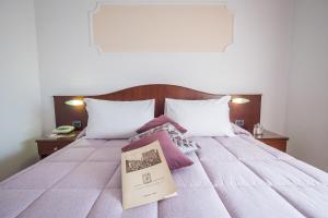 um livro sentado em cima de uma cama em Grifone Hotel Ristorante em Perugia