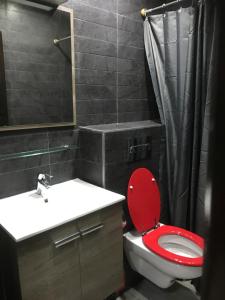 Un baño con un inodoro rojo y un lavabo. en Casablanca centre ville, en Casablanca 12 fotos más