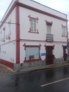 un edificio blanco con adornos rojos en una calle en Casa Dona Joaquina, en Reguengos de Monsaraz