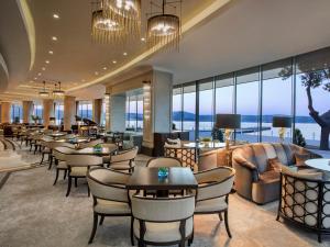 a restaurant with chairs and tables and windows at The Grand Tarabya Managed by Accor in Istanbul